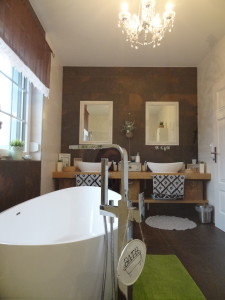 Badezimmer mit Dusche und freistehender Badewanne, Duschwand aus Glas, Duschgestänge, Fliesen in beige (Wand) braun (Boden)